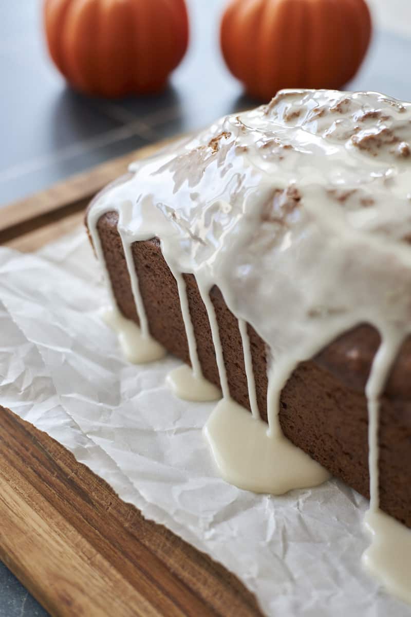 Side view of the glaze dripping on Sourdough Discard Pumpkin Bread.