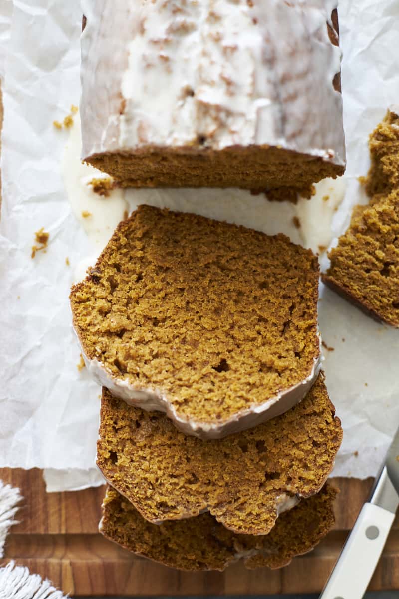 Slices of Sourdough Discard Pumpkin Bread on a wooden cuttinb board.