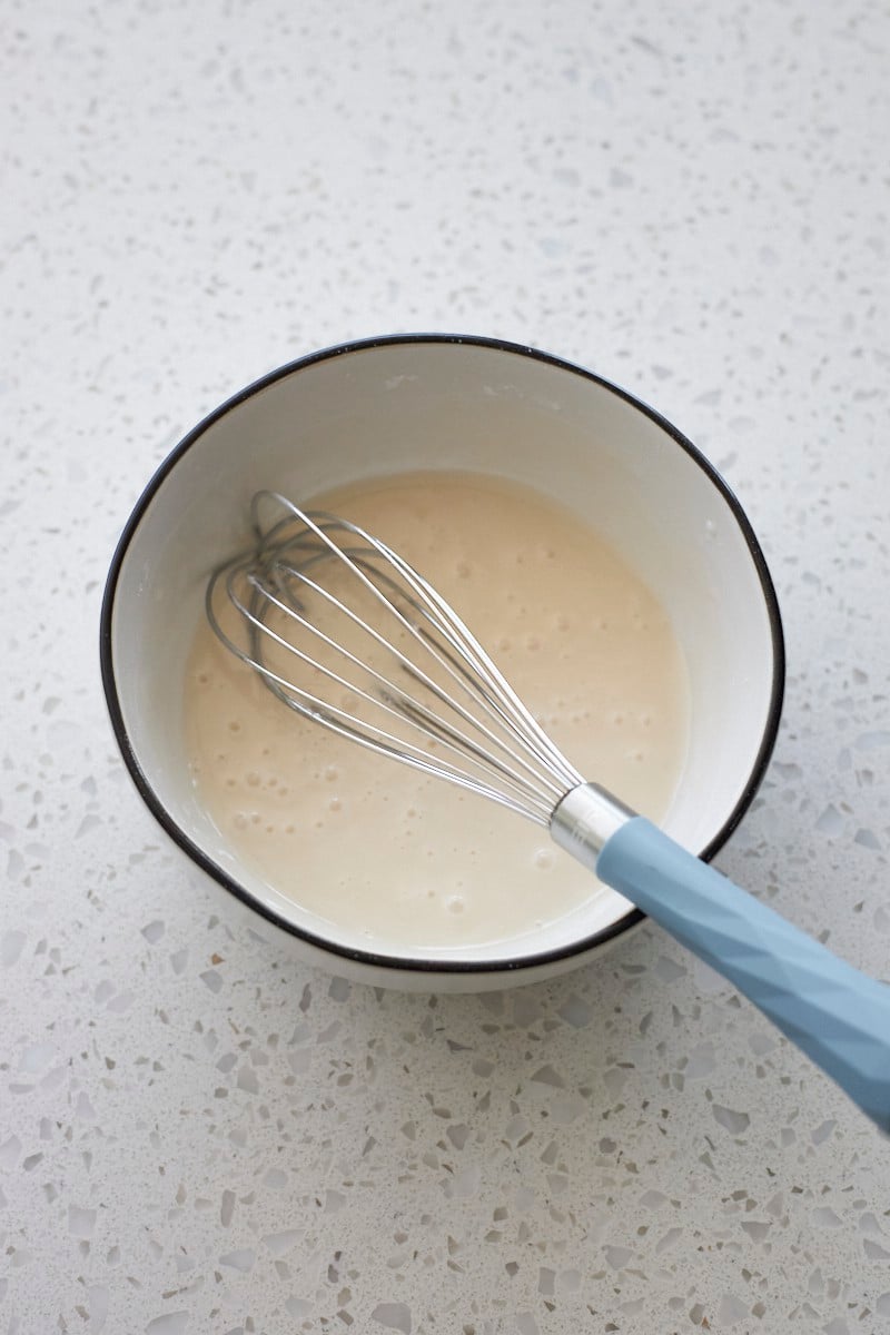 Glaze whisked in a small white bowl.