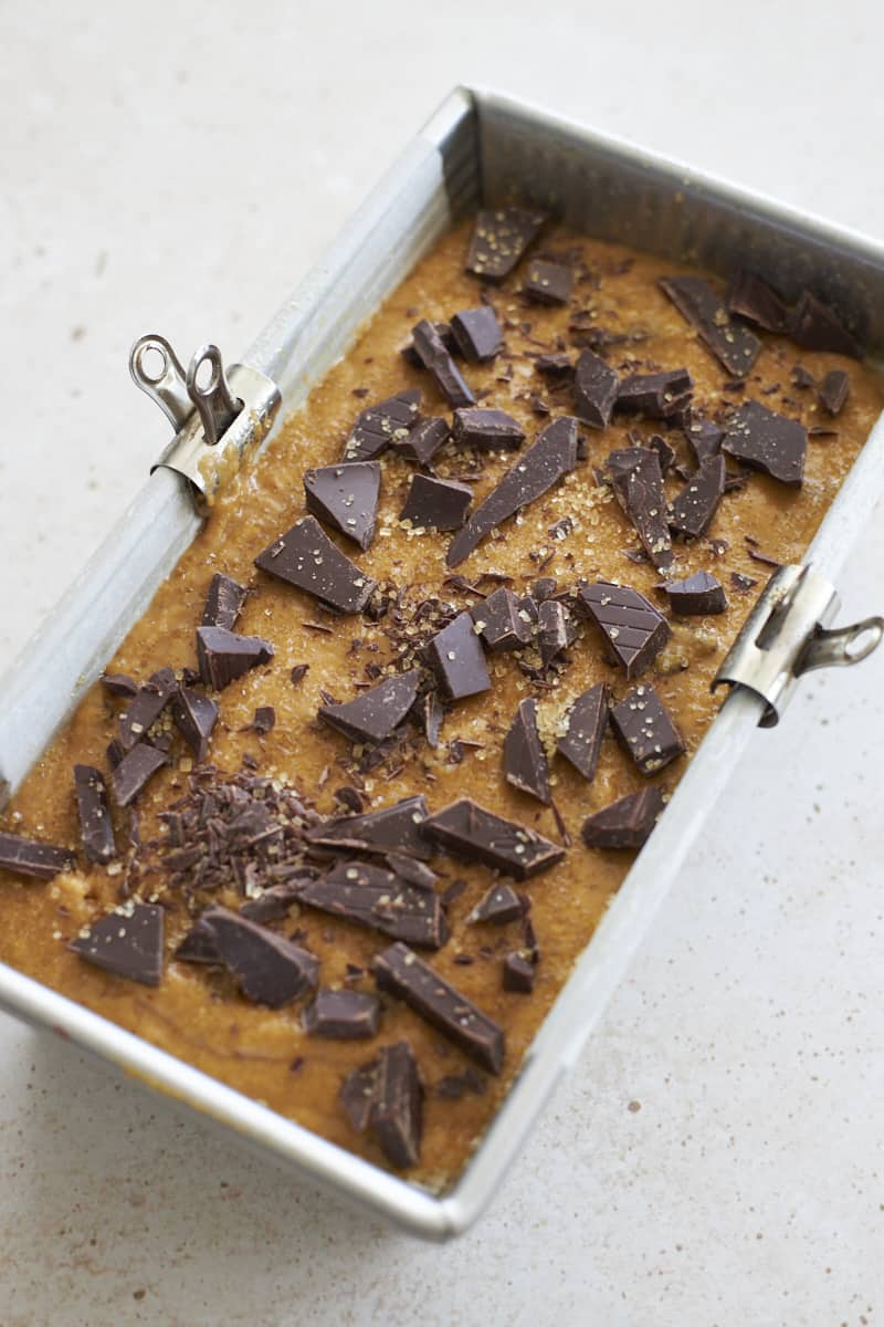 Batter in the baking pan, topped with turbinado sugar and chocolate chunks.