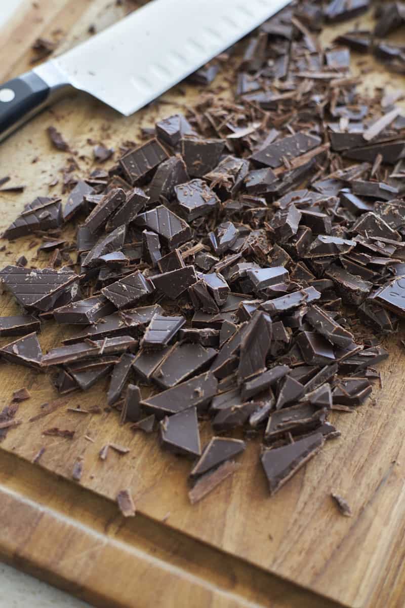 Chocolate chunks on a wooden cutting board.