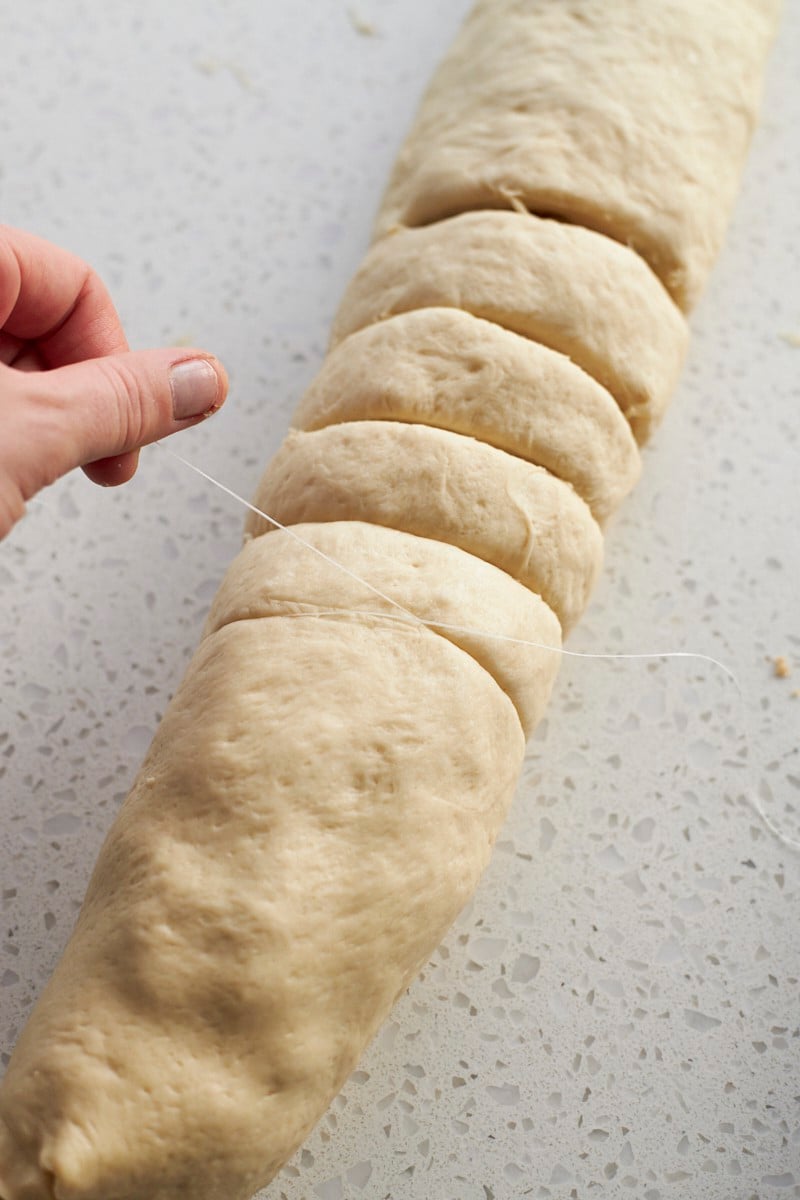 Cutting the cinnamon rolls with dental floss.