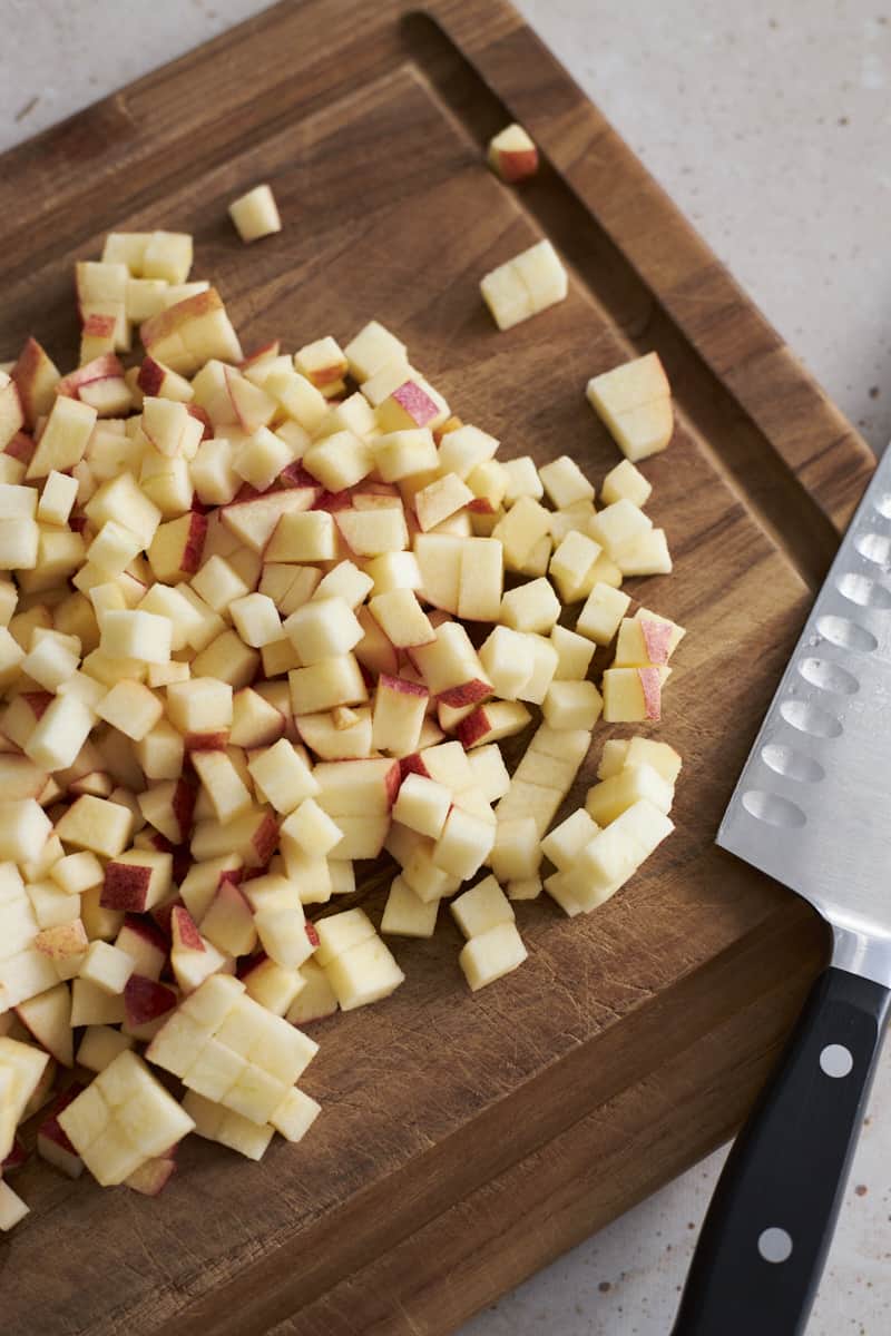 Diced apples on a wooden cutting board.