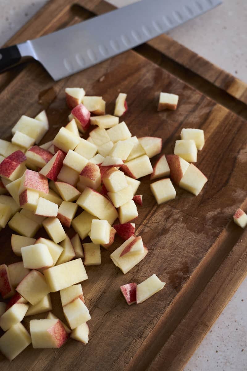 Diced apples on a wooden cutting board.