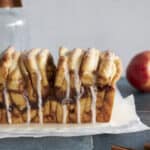 Side view of Sourdough Discard Apple Pull Apart Bread with glaze dripping.