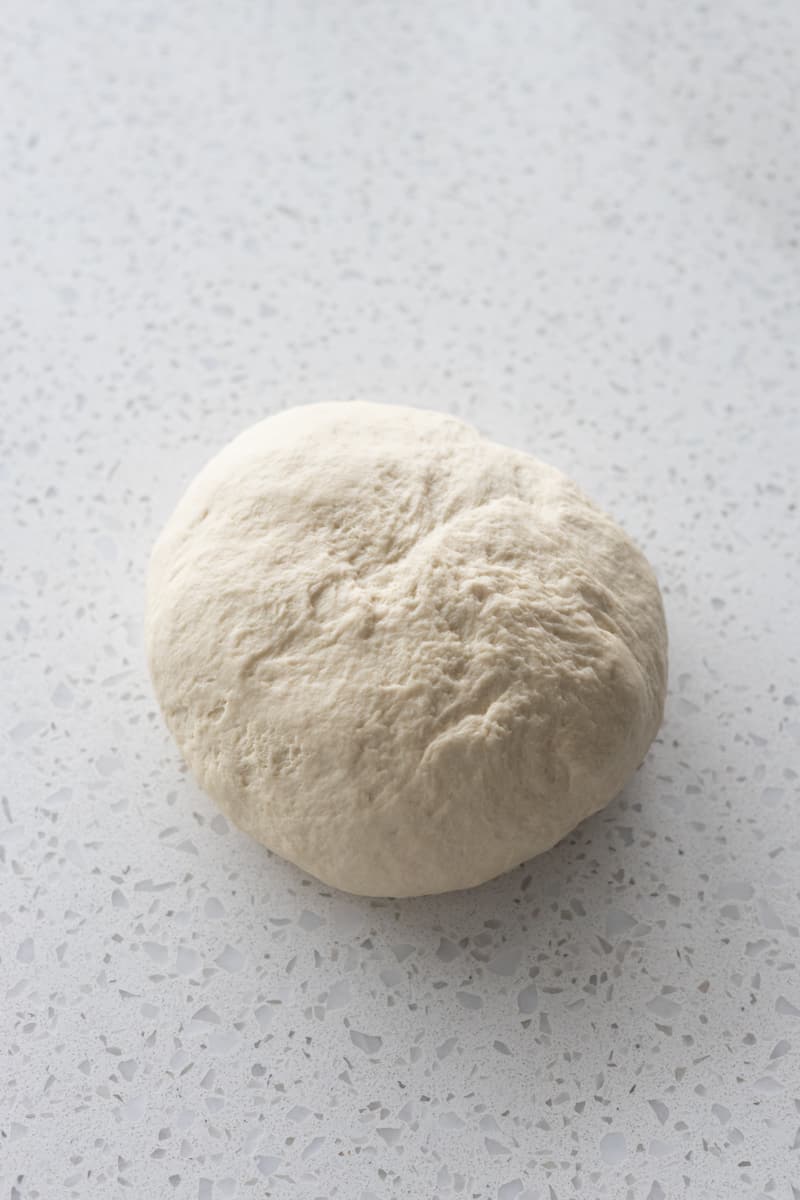 Smooth dough on work surface after kneading.