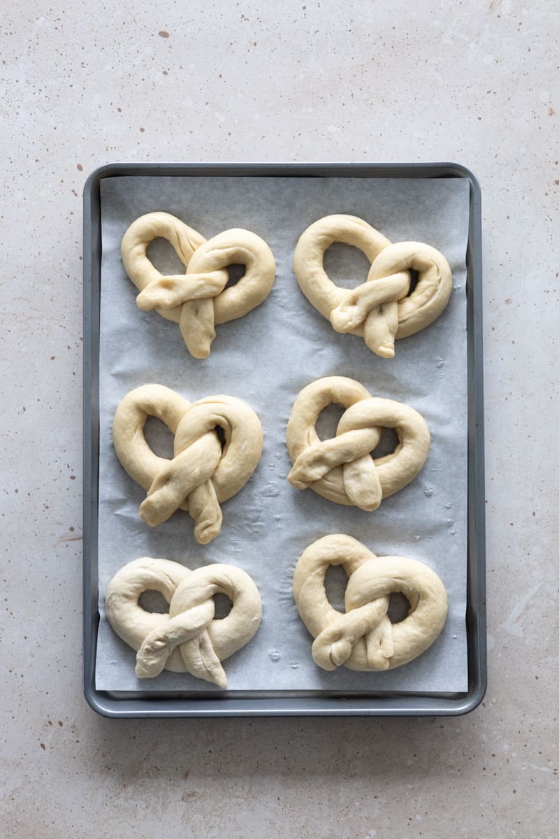 Pretzels shaped on a baking sheet.