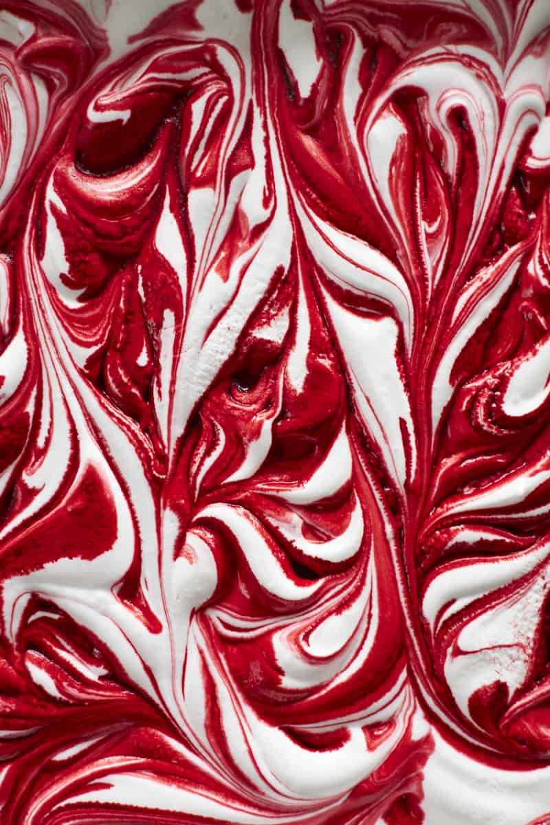 A closeup of red food coloring swirled through the marshmallows.