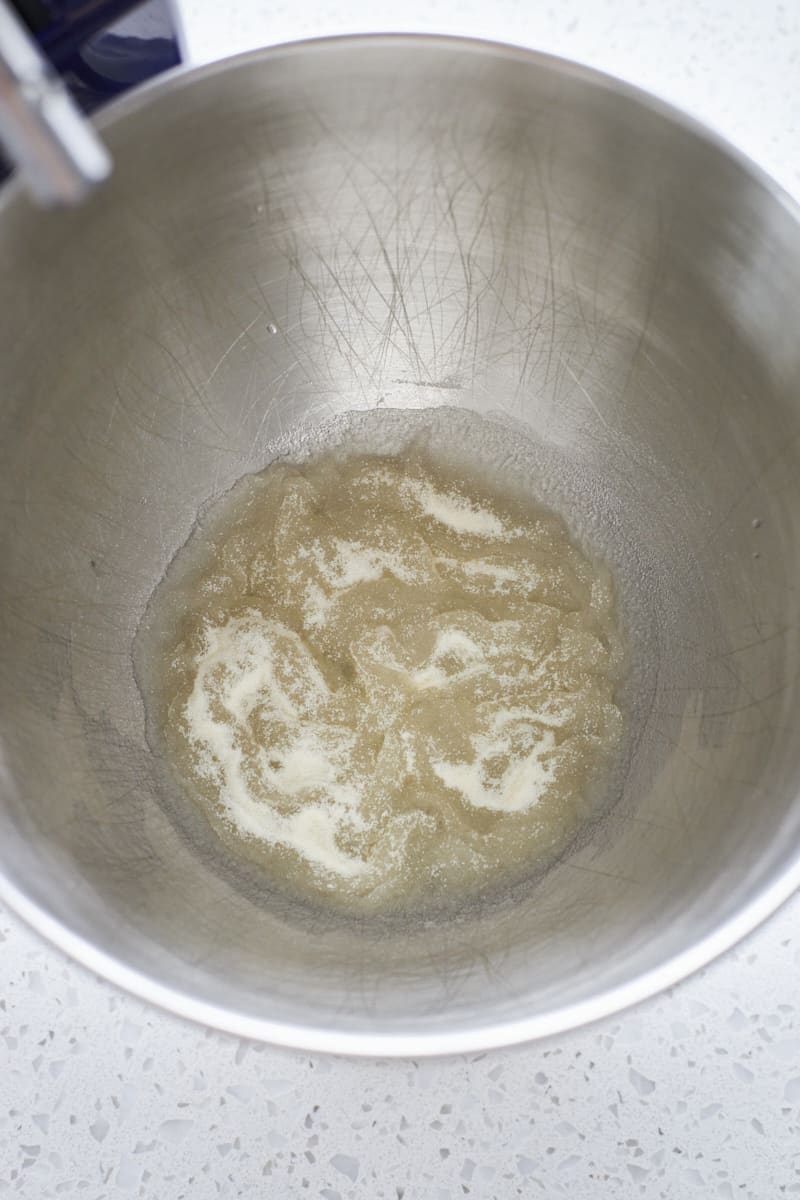 Gelatin bloomed in the bowl of a stand mixer.