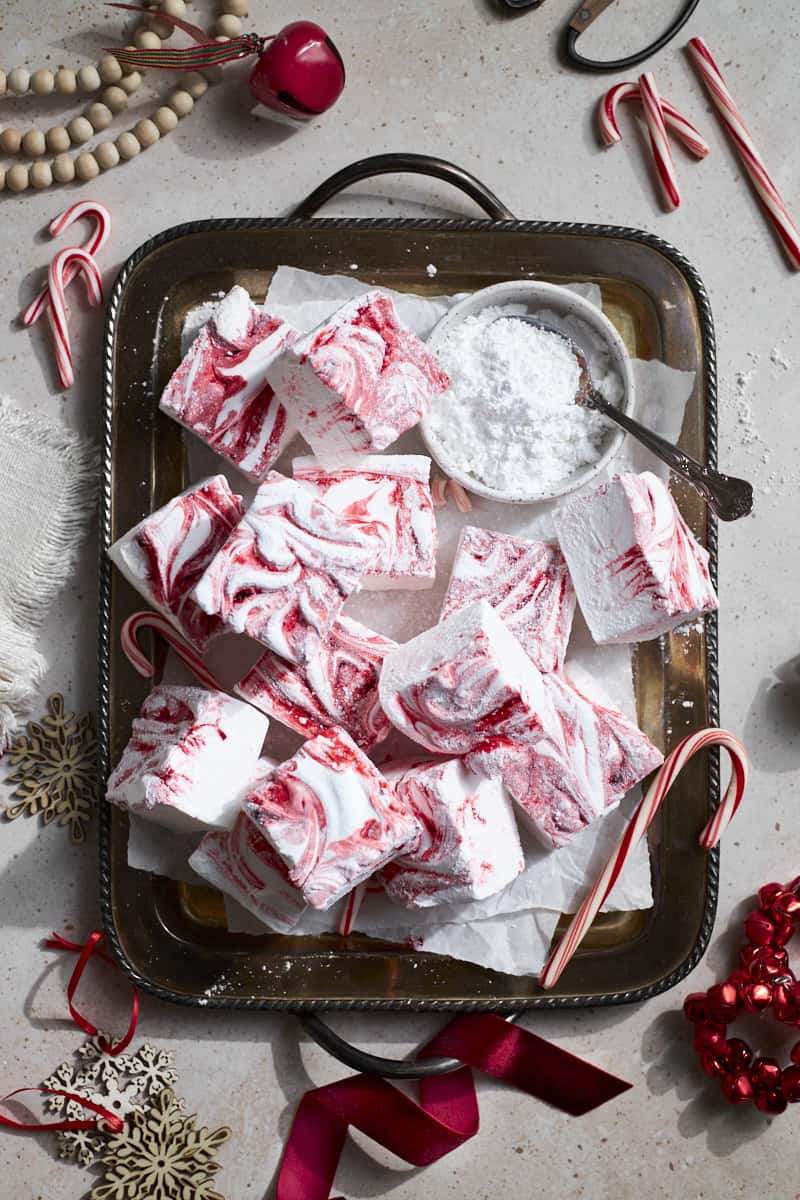 Candy Cane Marshmallows on a tray with candy canes.