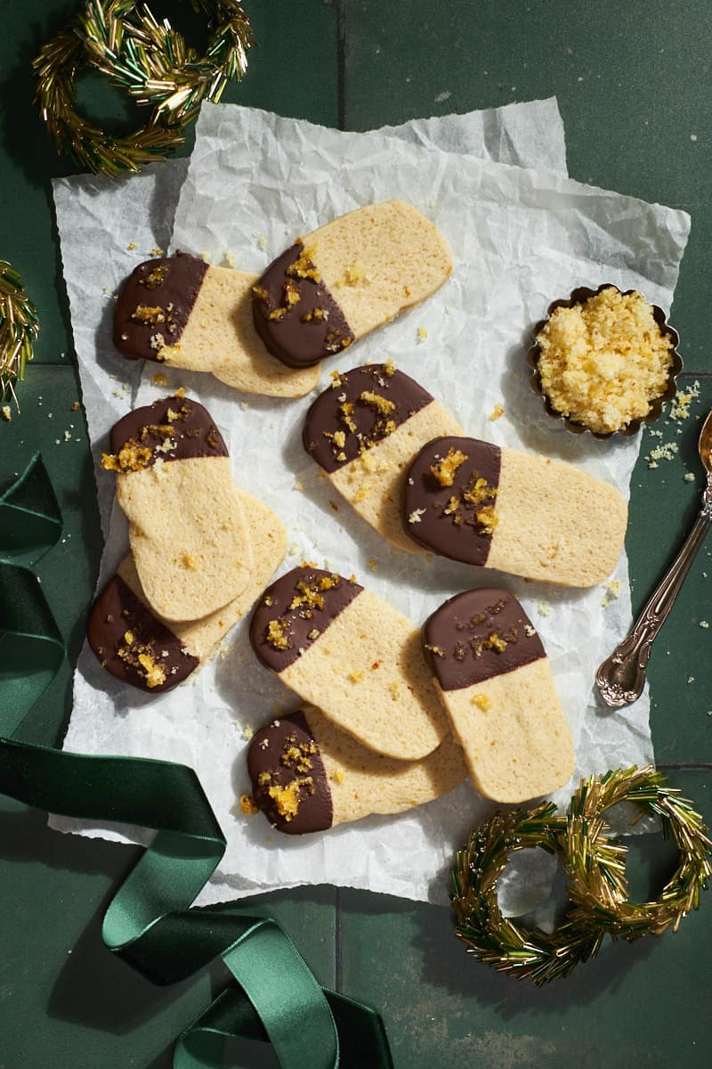 A pile of Sourdough Discard Shortbread Cookies on white parchment paper.