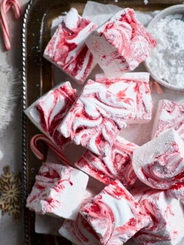 Candy Cane Marshmallows on a tray with candy canes.