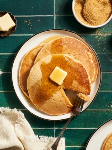 A stack of Sourdough Discard Pancakes with butter and maple syrup.