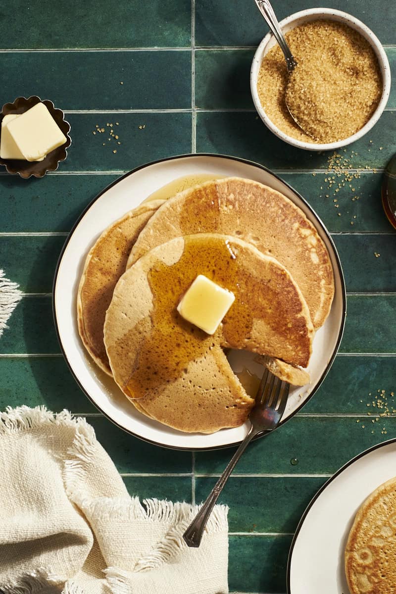 A stack of Sourdough Discard Pancakes with butter and maple syrup.