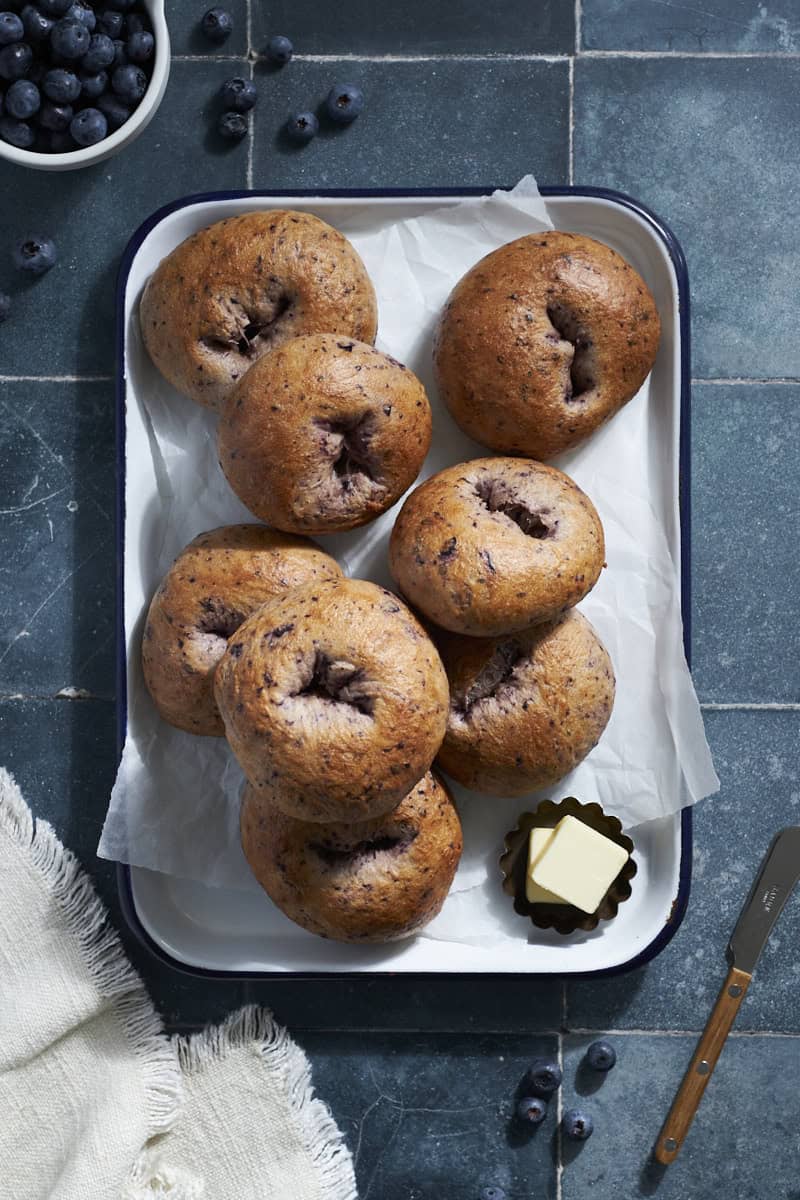 Sourdough Discard Blueberry Bagels on a white tray.