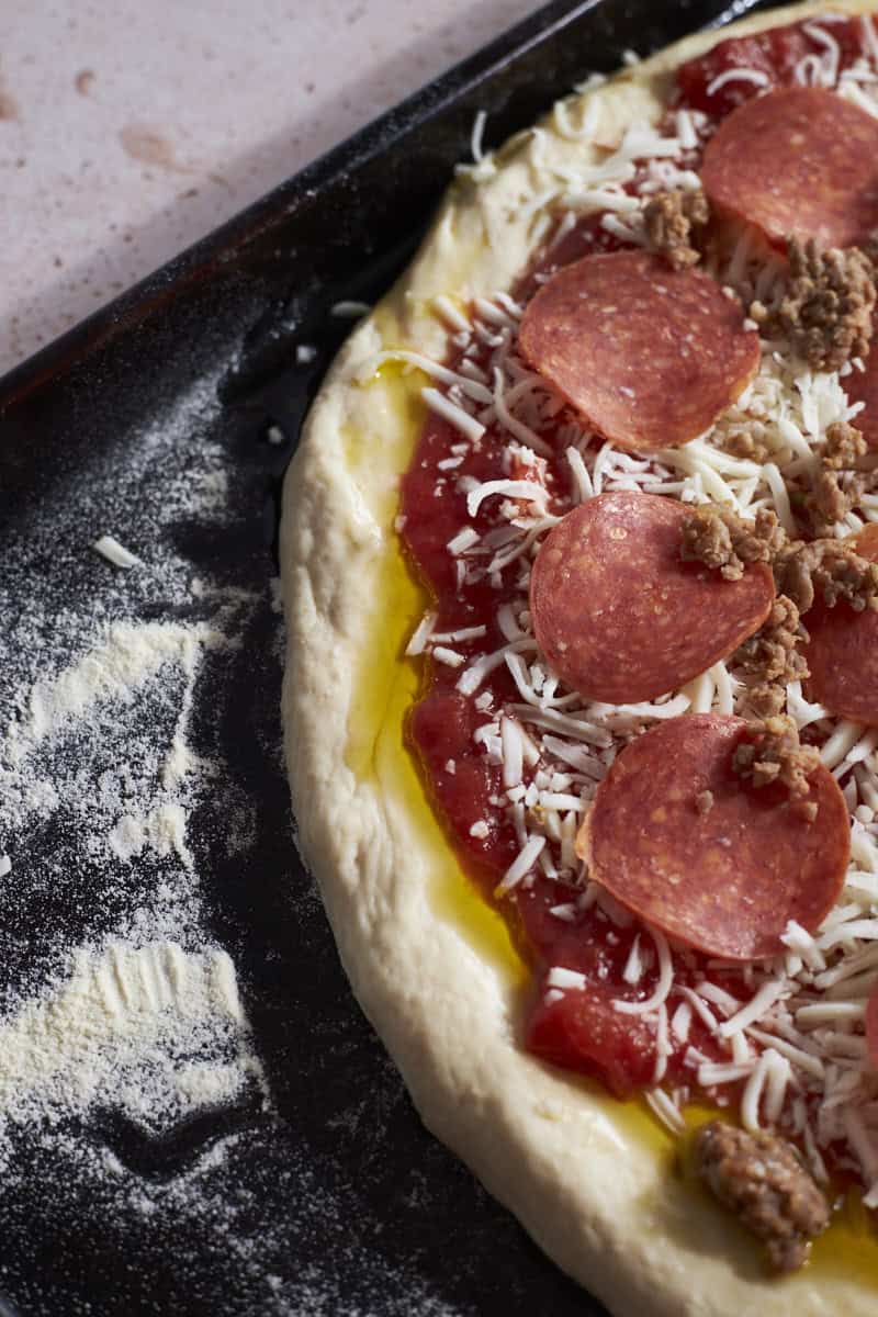 An overhead view of Sourdough Discard Pizza Dough with thick crust before baking.