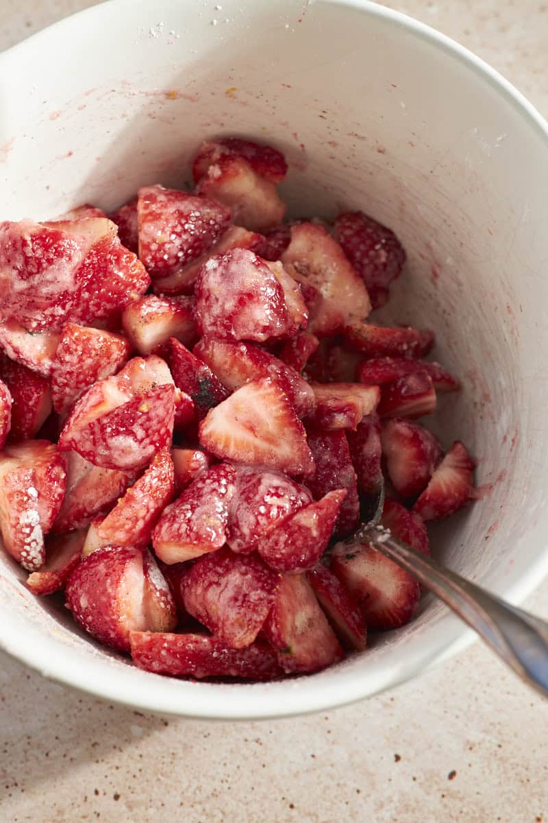 Strawberries mixed with other filling ingredients in a large bowl.