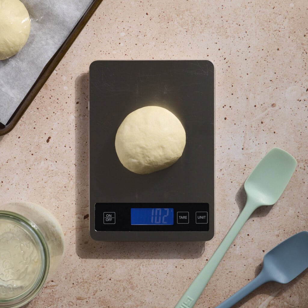 Dough being weighed on a kitchen scale.