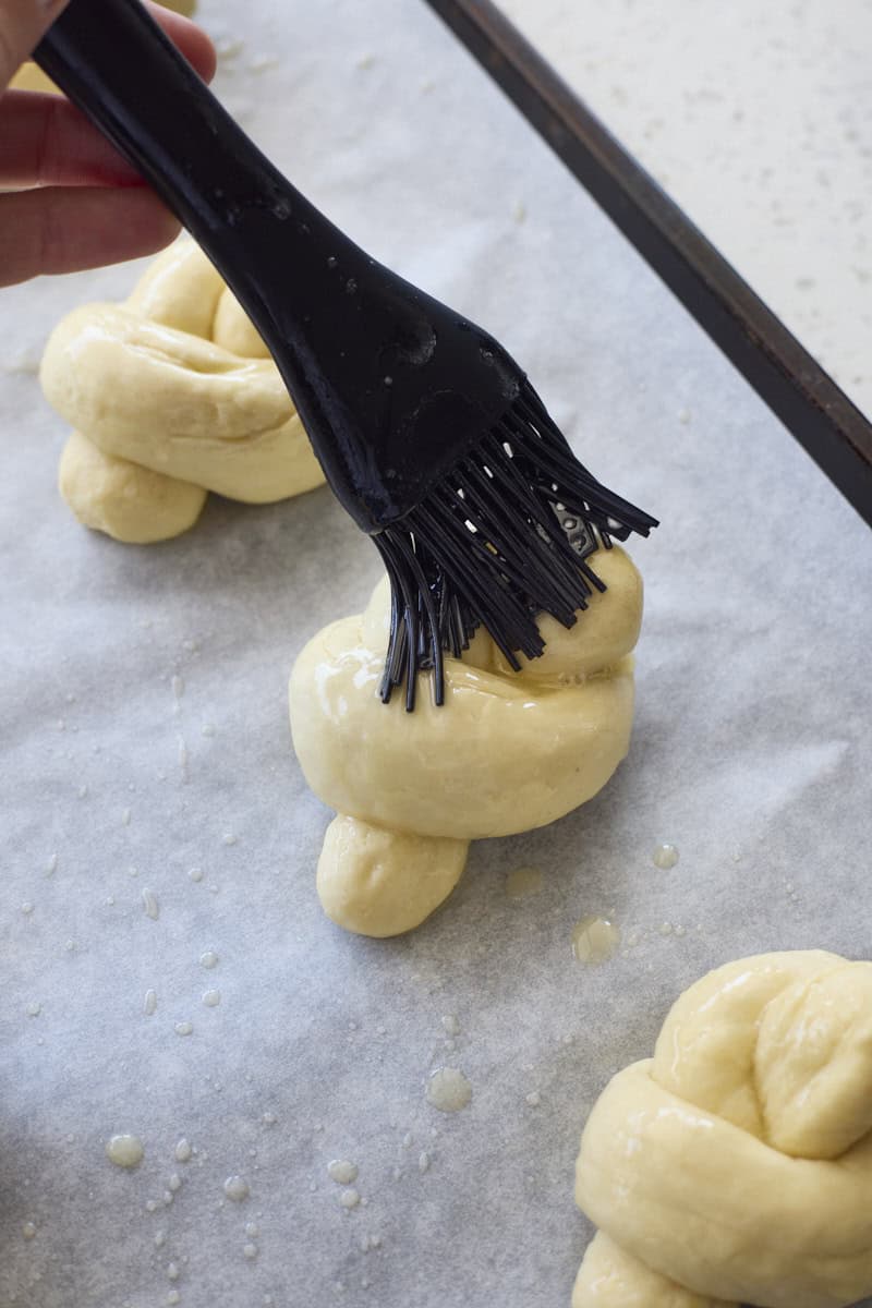 Brushing a garlic knot with butter.