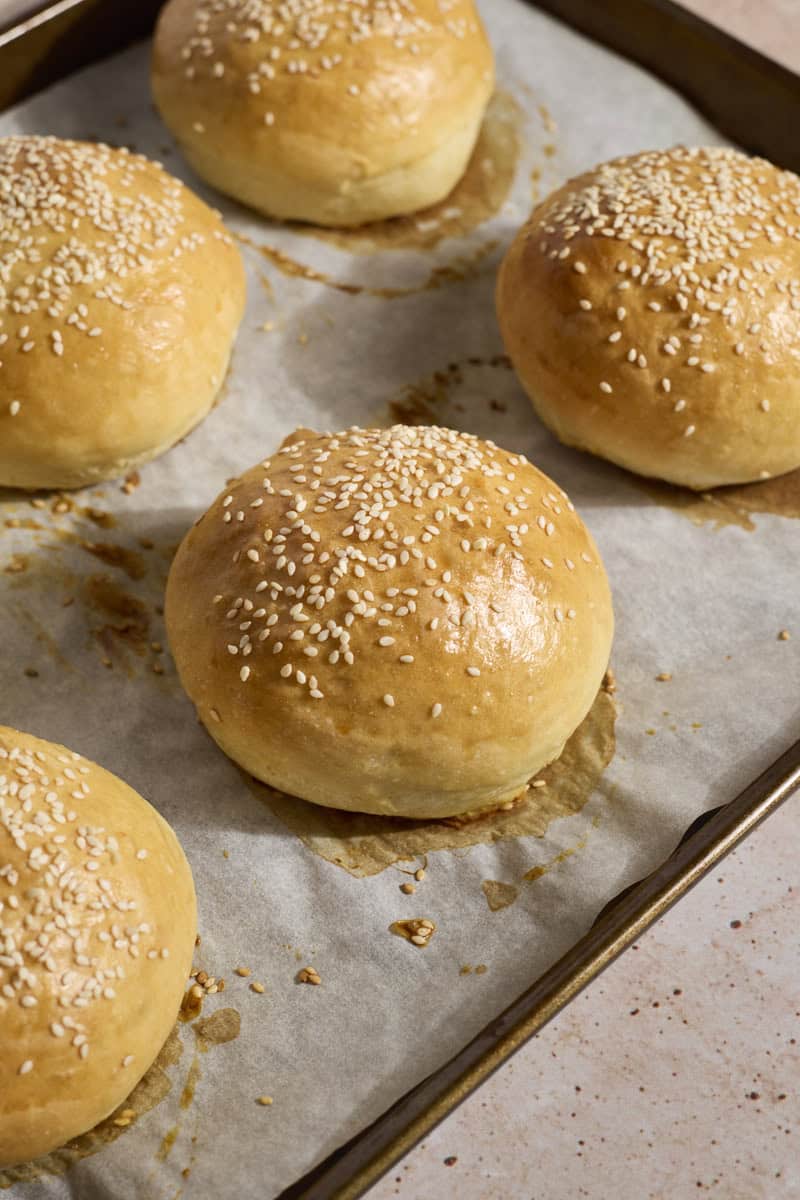 Baked Sourdough Discard Hamburger Buns on a baking sheet.