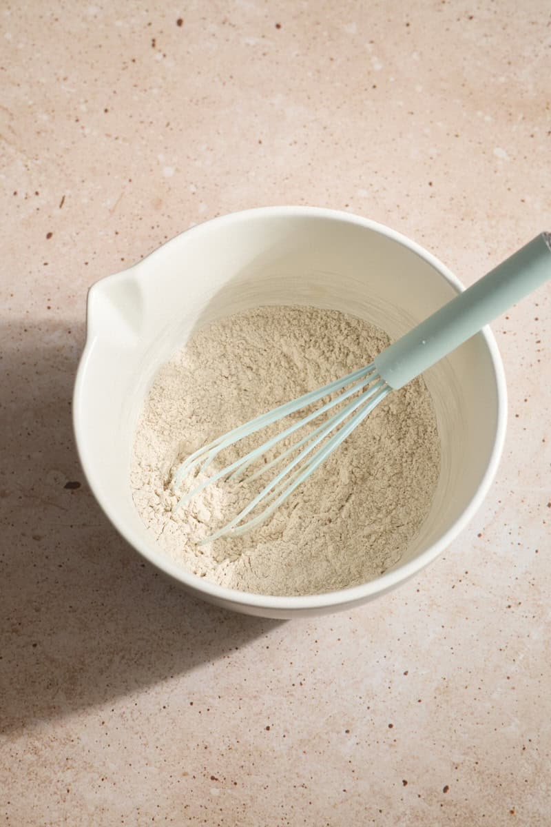Dry ingredients whisked together in a white bowl.