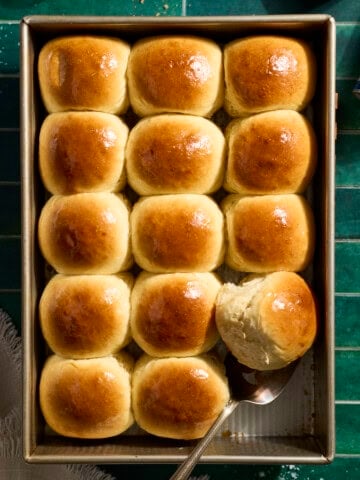 An overhead view of Sourdough Discard Hawaiian Rolls in the baking pan.