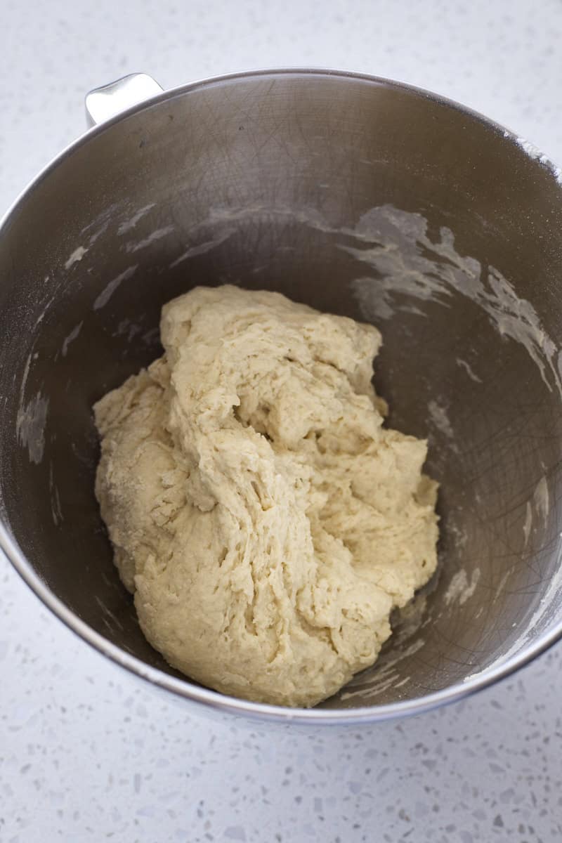 Shaggy dough in the bowl of a stand mixer.