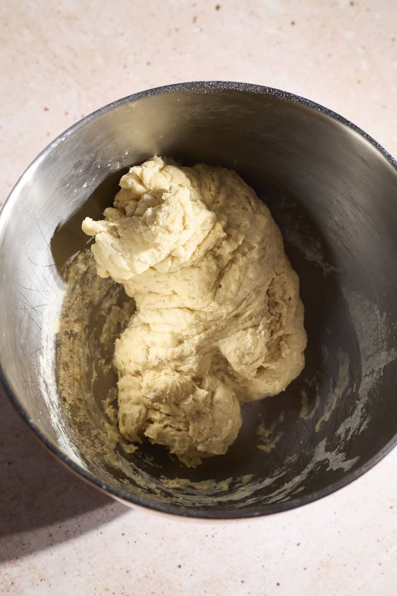 Dough mixed in the bowl of a stand mixer.