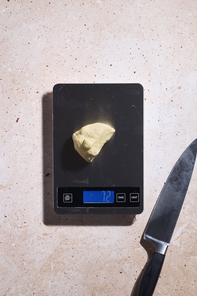 Dough being weighed on a kitchen scale.