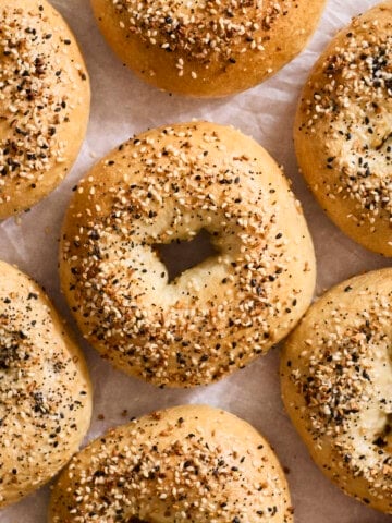 Homemade Everything Bagels on white parchment paper.