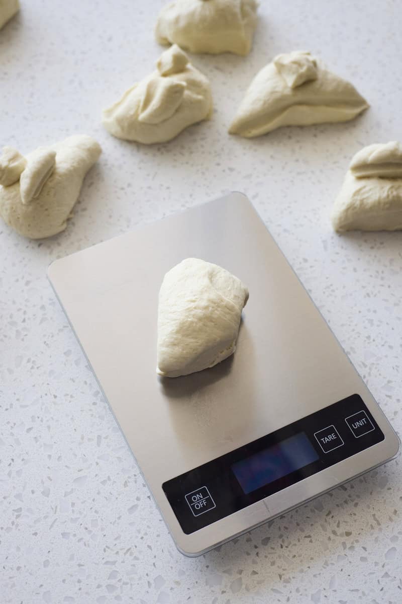 Dough being divided on a kitchen scale.