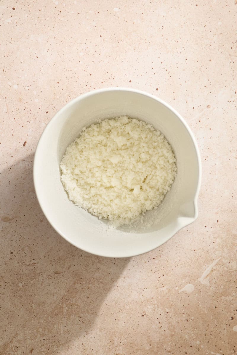 Butter and sugar mixed in a white mixing bowl.