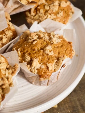 Sourdough Discard Pumpkin Muffins in a pile on a white platter.