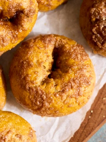 Sourdough Discard Pumpkin Bagels in a stack on a wooden tray.
