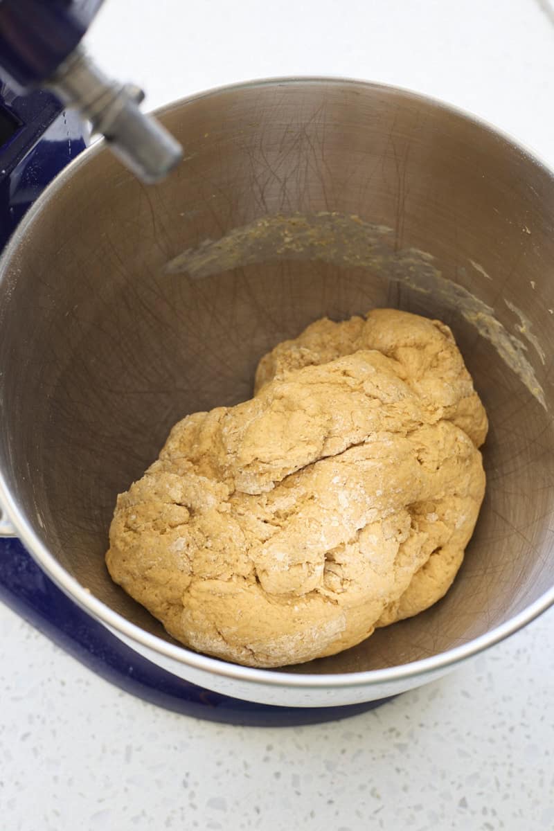 Shaggy dough in the bowl of a stand mixer.