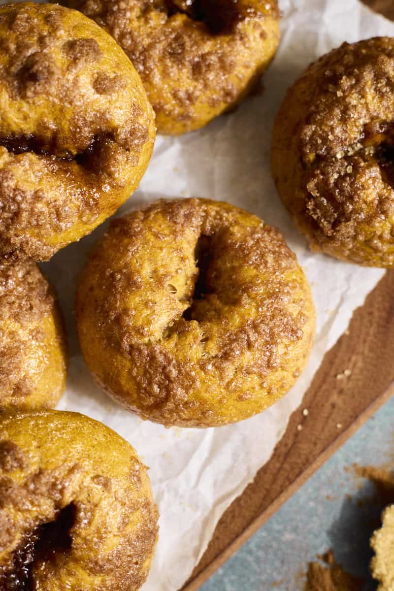 Sourdough Discard Pumpkin Bagels in a stack on a wooden tray.
