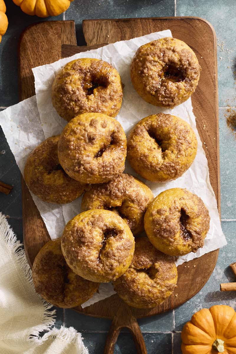 Sourdough Discard Pumpkin Bagels in a stack on a wooden tray.