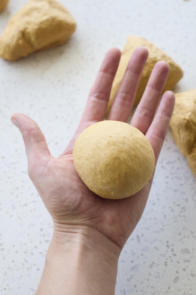 Dough shaped into a roll in a palm.