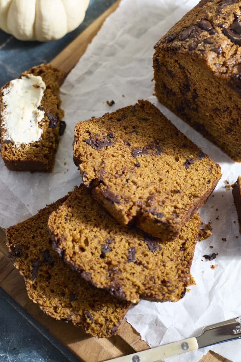 Slices of Sourdough Discard Pumpkin Chocolate Chunk Bread laying on white parchment paper.