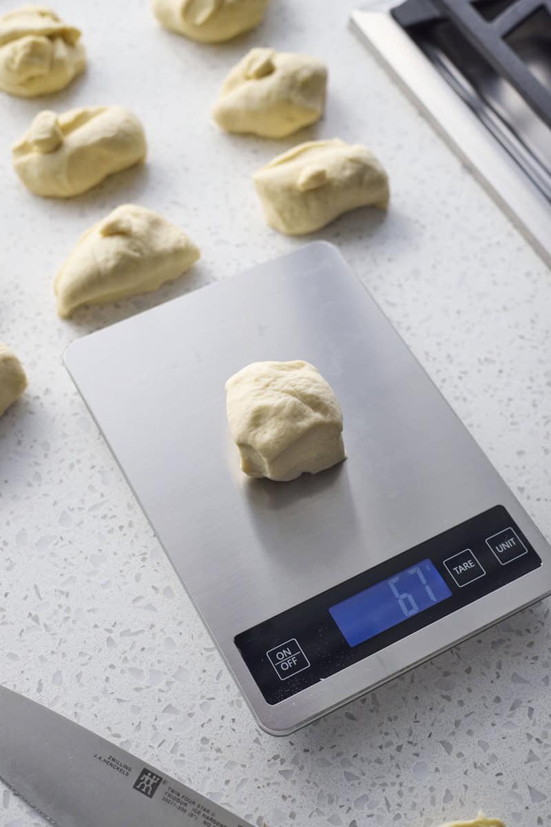 Dough being divided on a kitchen scale.