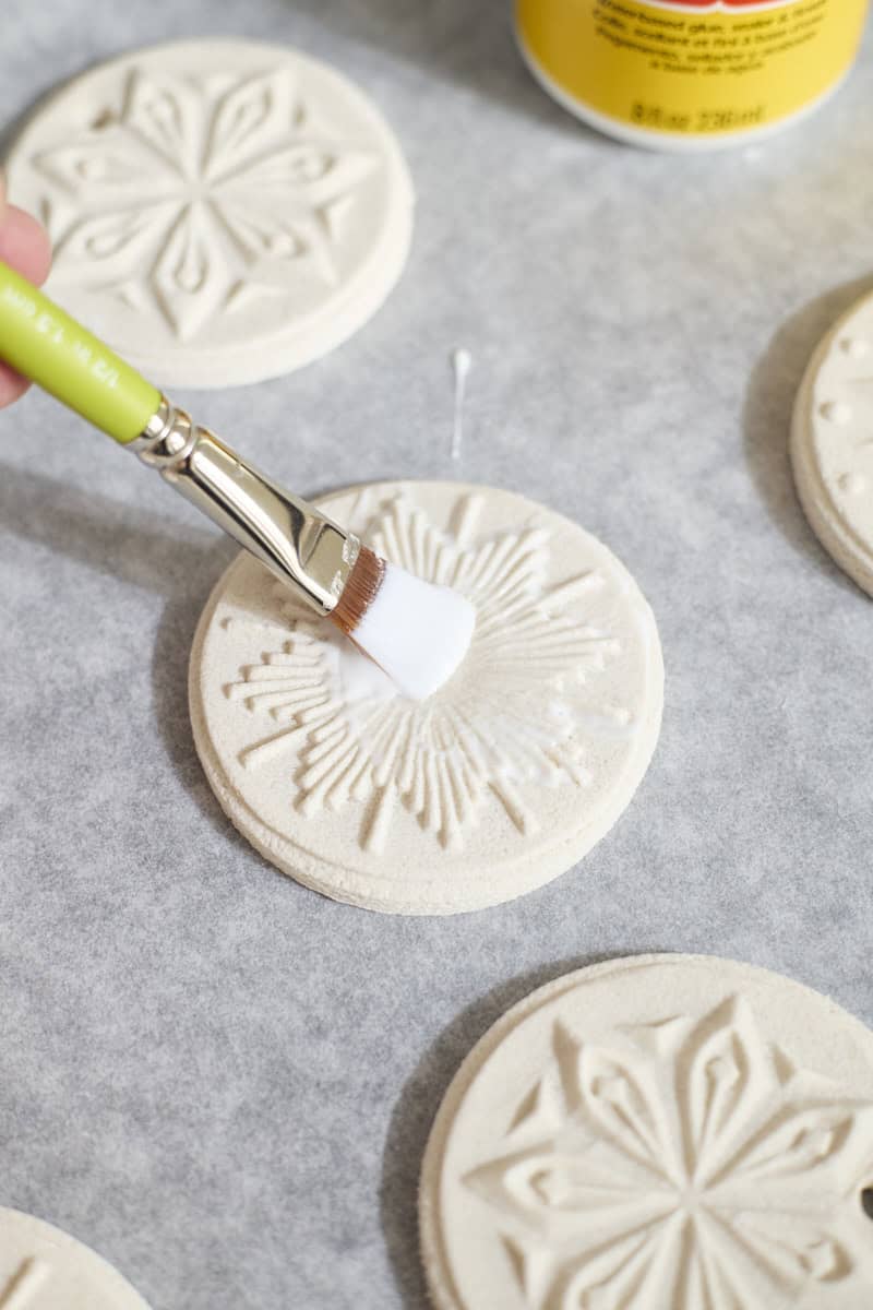 An ornament being brushed with Mod Podge.