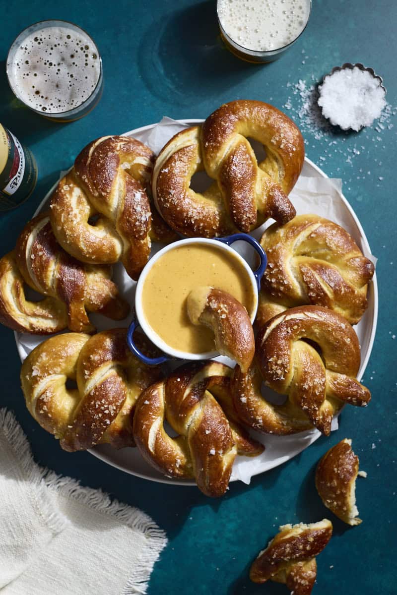 An overhead view of a platter of soft pretzels with a bowl of Beer Cheese in the middle.