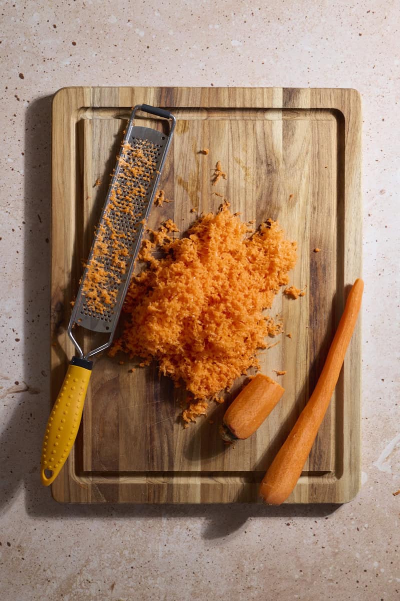 Carrots grated on a wooden cutting board.
