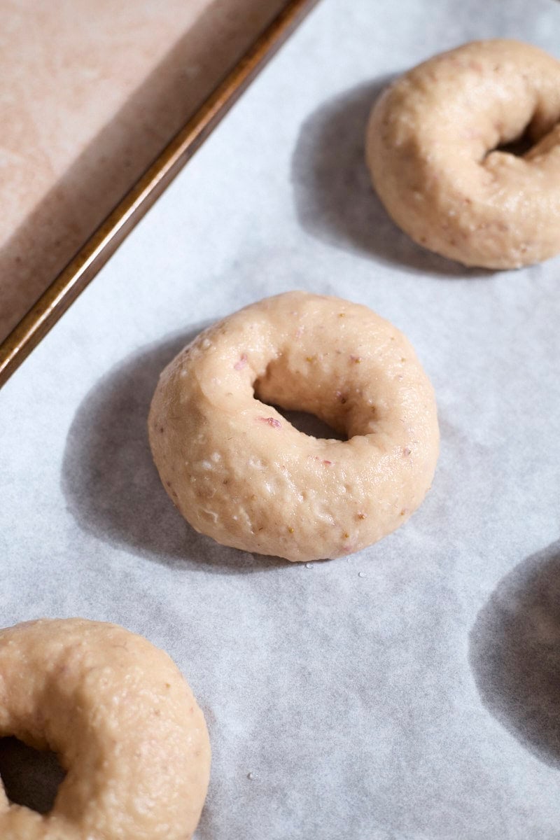 Bagels on a baking sheet ready to bake.
