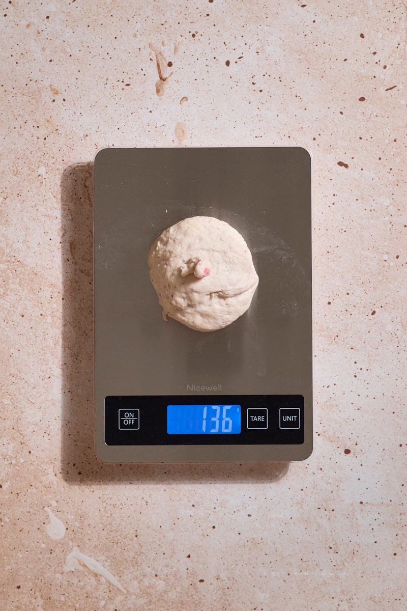 Dough being weighed on a kitchen scale.