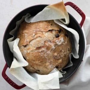 An overhead view of No-Knead Walnut Raisin Bread in a Dutch oven.