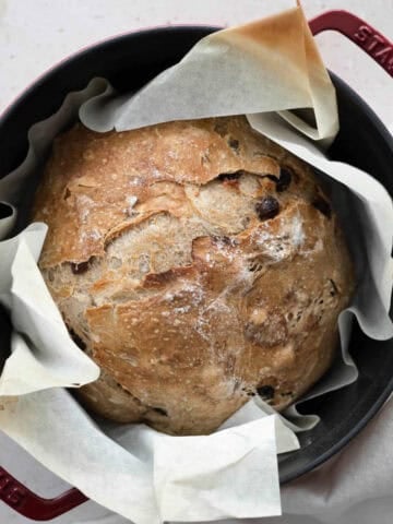 An overhead view of No-Knead Walnut Raisin Bread in a Dutch oven.