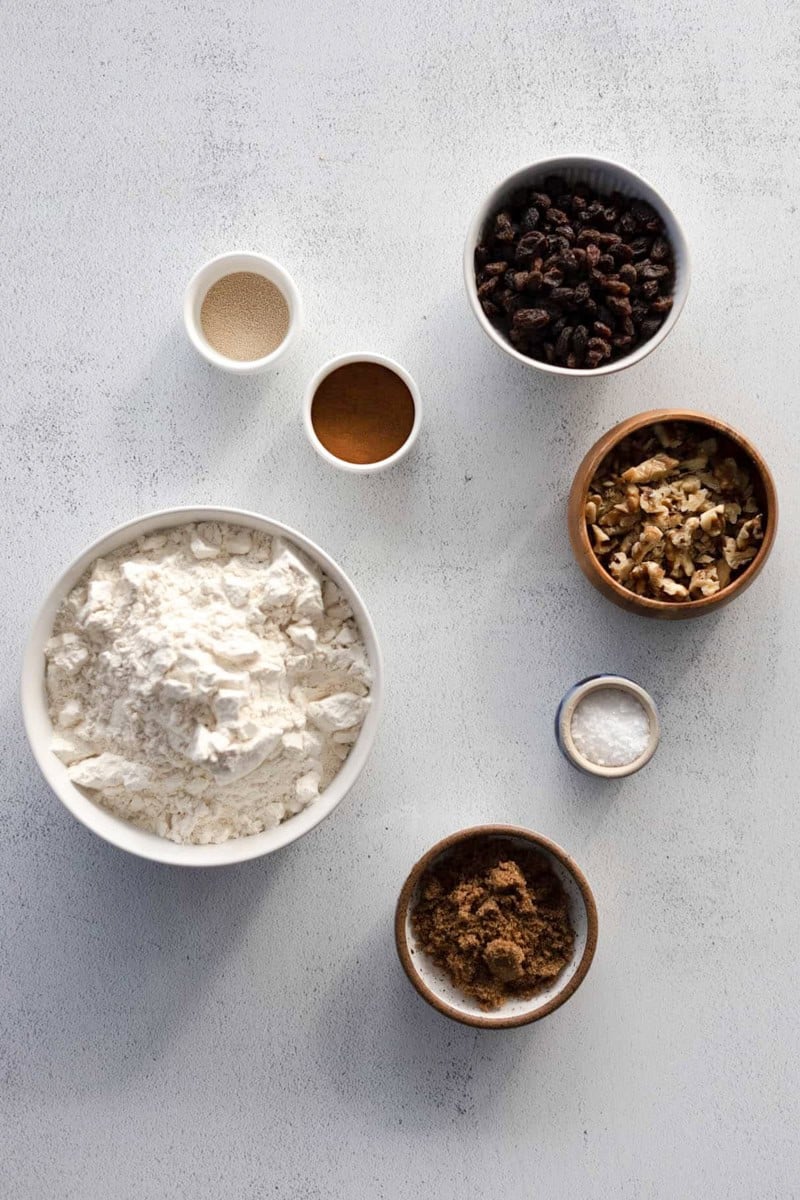 Ingredients for No-Knead Walnut Raisin Bread in small bowls.