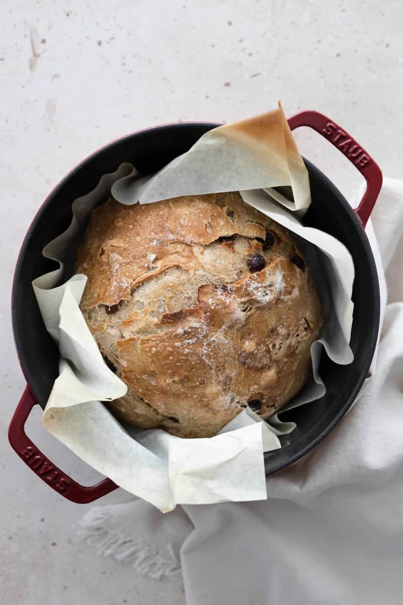 An overhead view of No-Knead Walnut Raisin Bread in a Dutch oven.