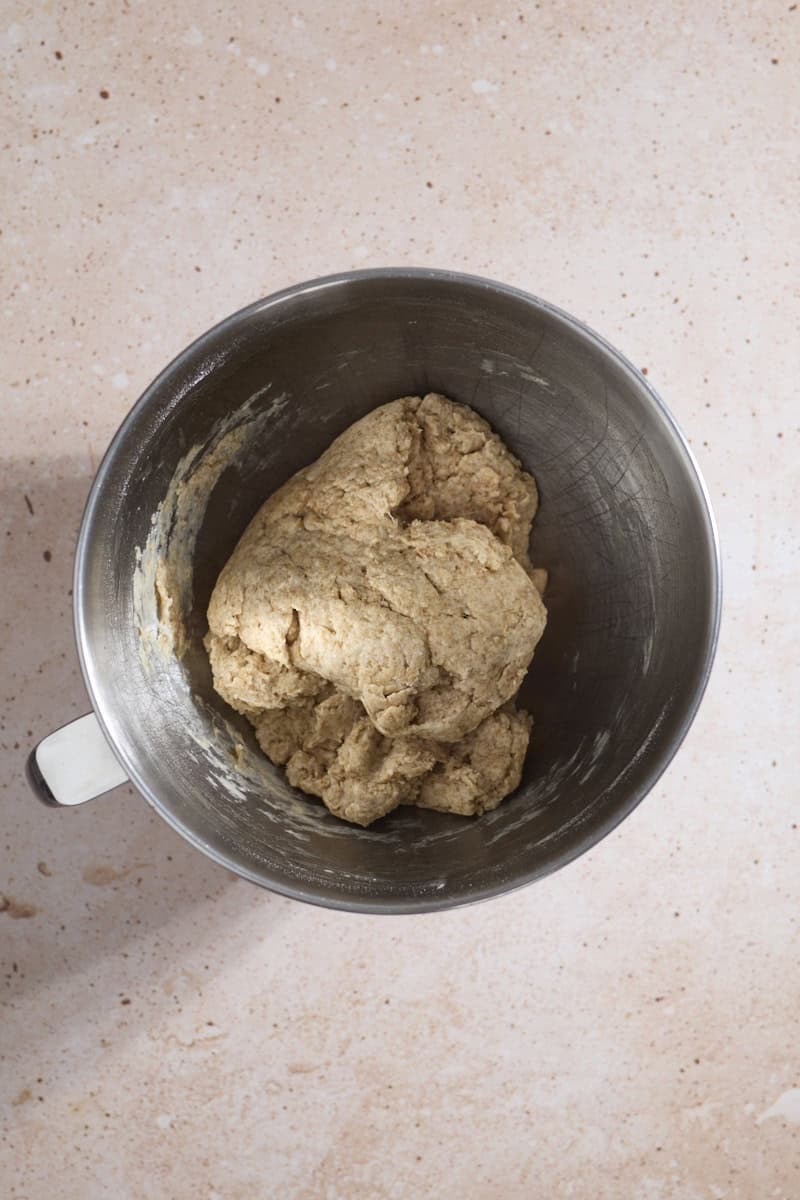 Rough dough in the bowl of a stand mixer.